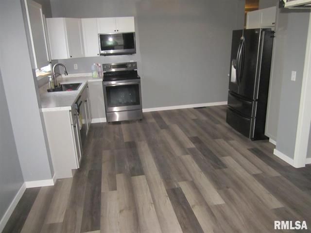 A kitchen with stainless steel appliances and a black refrigerator