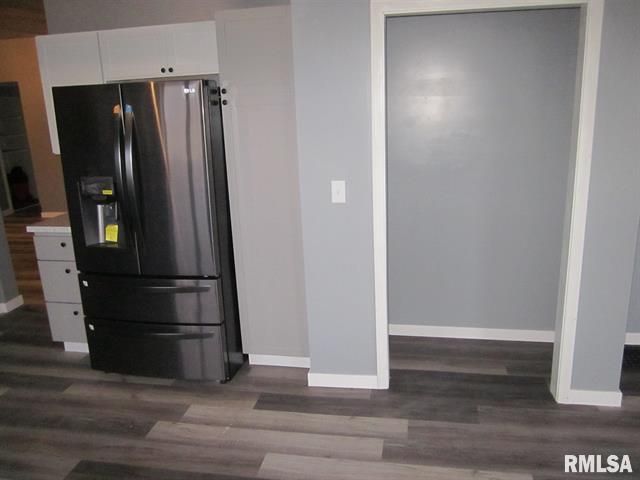 An empty kitchen with a stainless steel refrigerator