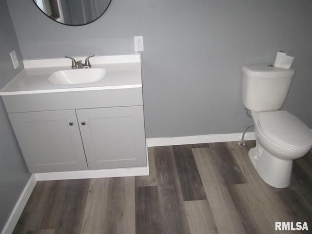 A bathroom with a toilet a sink and a mirror