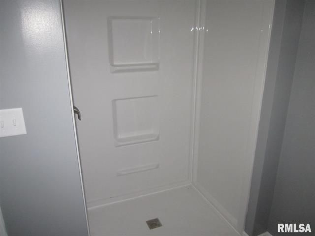 A bathroom with a shower stall and a sink.