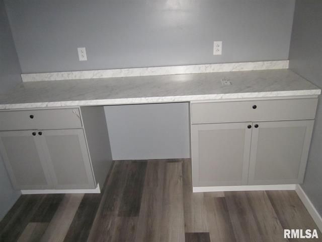 An empty room with a desk and cabinets in it.