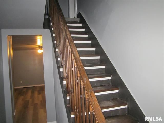 A staircase with a wooden railing and a sign that says rmlsa