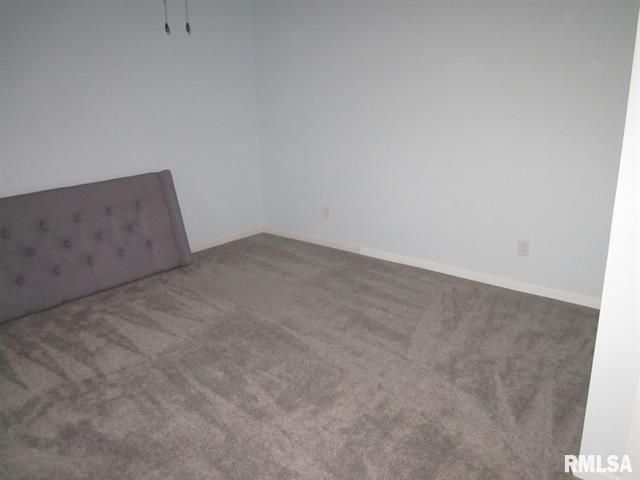 An empty bedroom with a couch and a bed