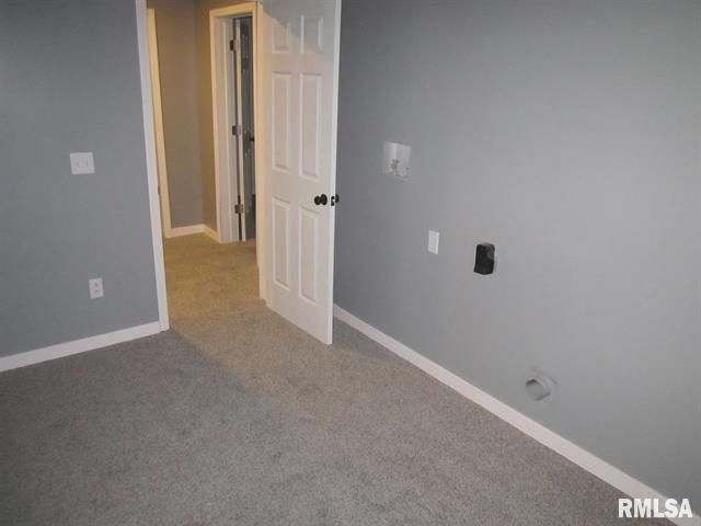 An empty room with gray walls and a white door