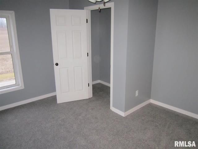 An empty room with a door and a window.