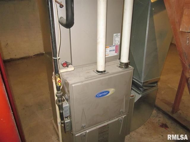 A carrier air conditioner is sitting on the floor in a room.