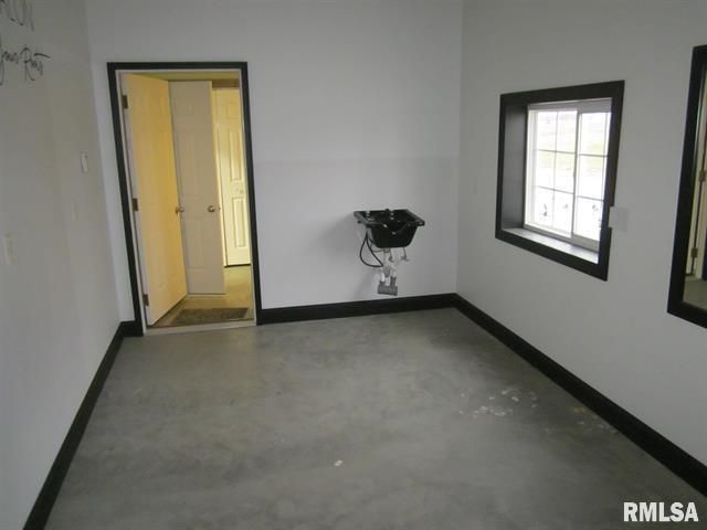 An empty room with a sink and a window with rmlsa written on the bottom