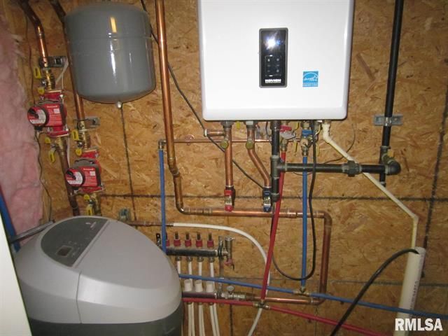 A room with a water heater and a rmlsa logo on the wall