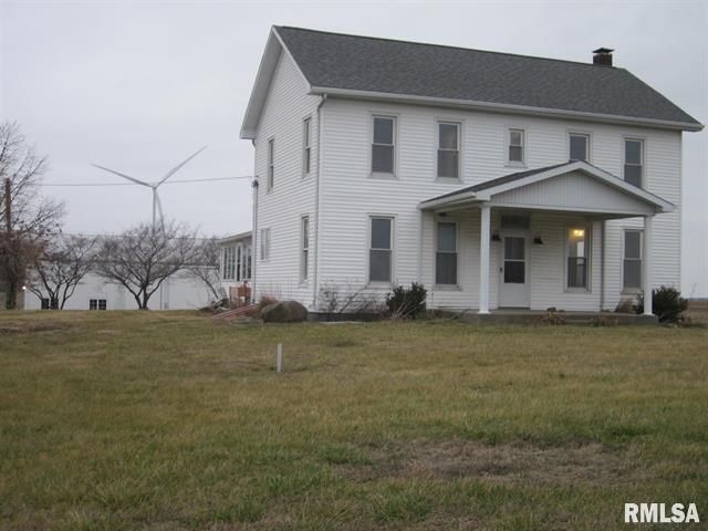A large white house with a windmill in the background