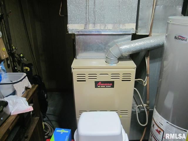 Furnace with vent pipes, water heater in a basement setting.