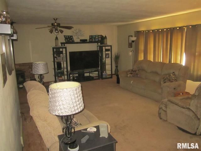 Living room with brown couches, carpet, and media center.