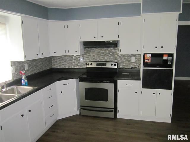 White kitchen cabinets with a stainless steel stove