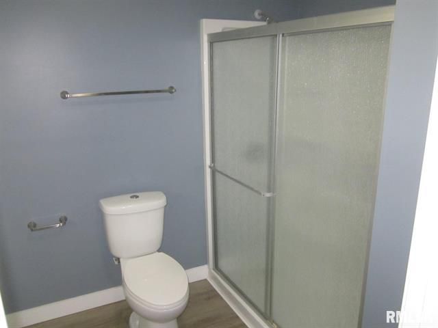 Bathroom with a toilet, shower, and towel rack against blue walls
