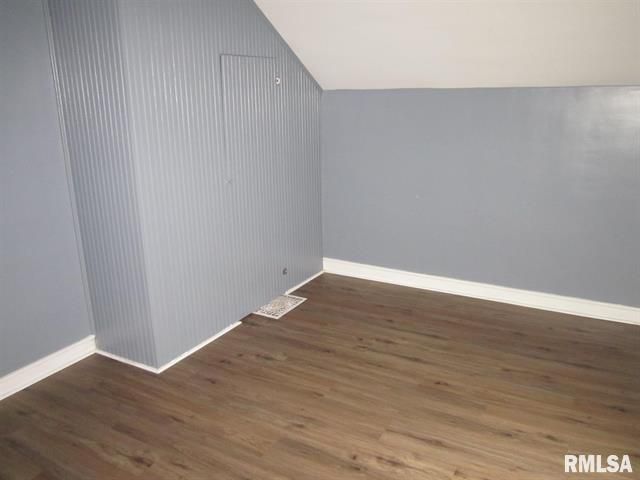 Empty room with gray walls, wood floor, and white trim