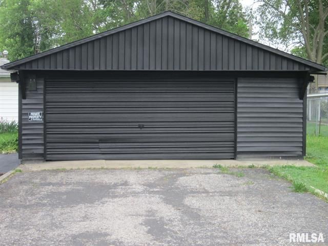Black garage with a driveway