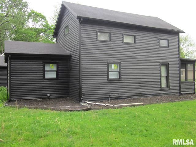Black house with dark trim, windows, and roof