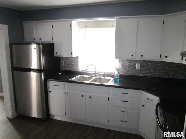 White kitchen with stainless steel fridge
