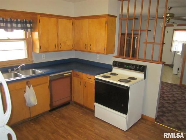 Kitchen with light wood cabinets, blue countertop, and a white stove.