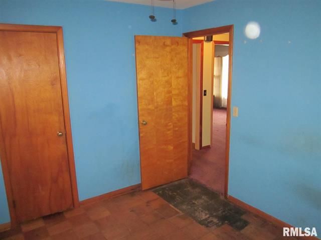 Room with blue walls, two doors, and a doorway to another room with pink carpet.