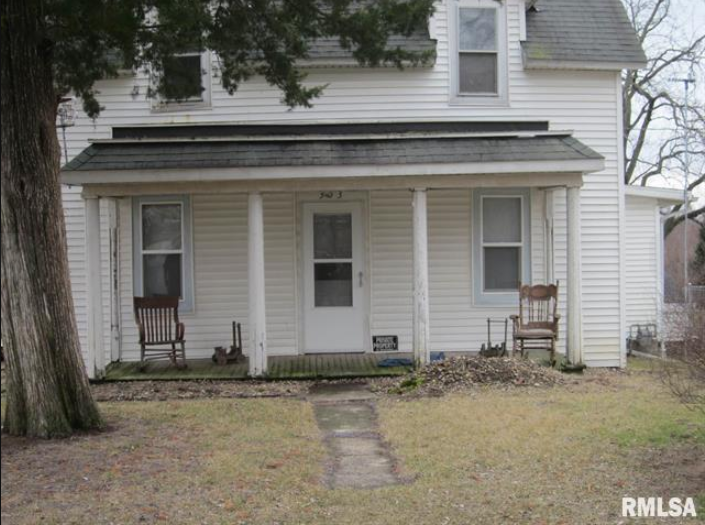 Blue and white ranch-style house with a single-car garage. Brown grass in the front yard. Bare trees in the background.