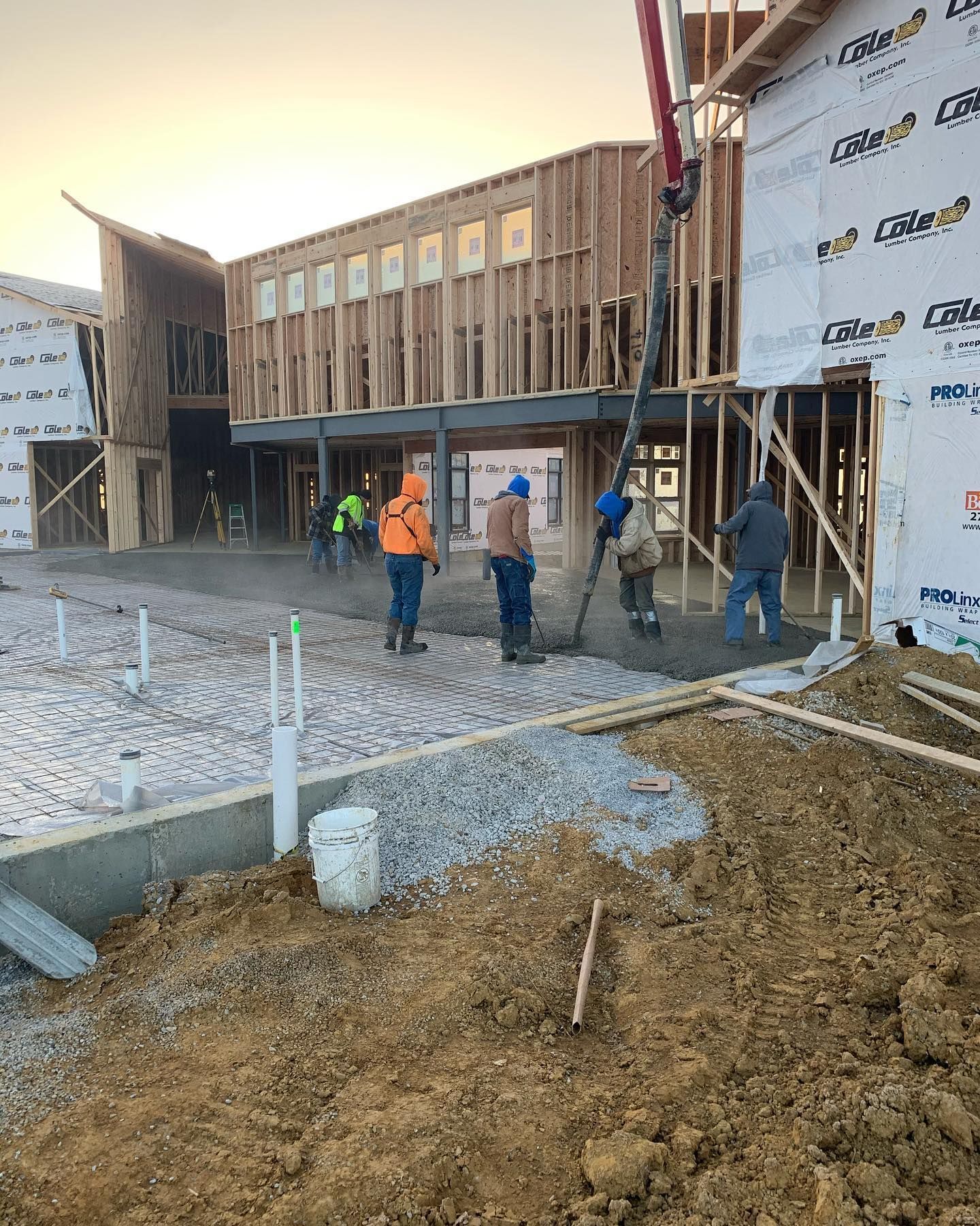A group of construction workers are standing in front of a building under construction.