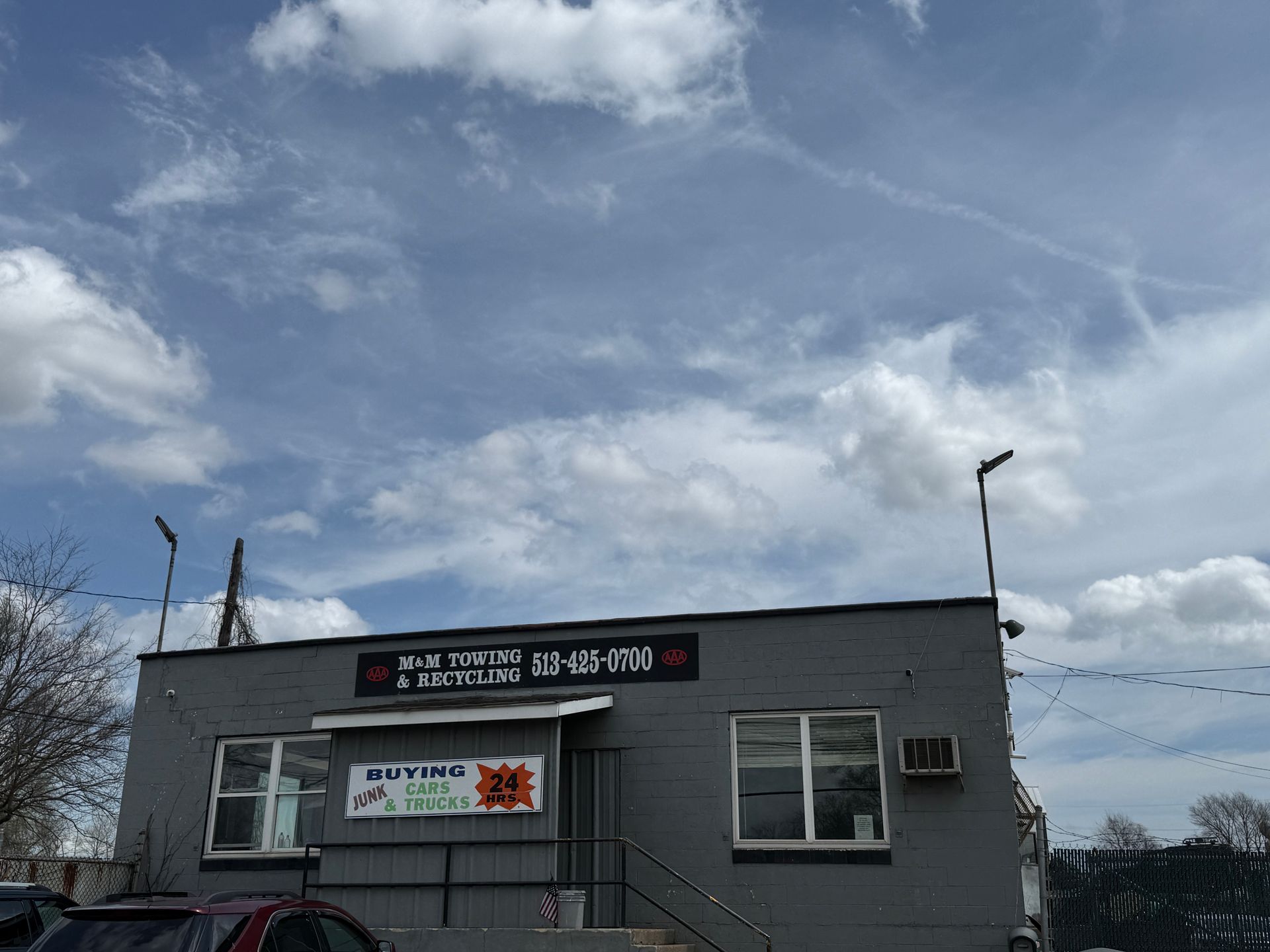 A grey, one-story commercial building under a blue sky, featuring a 