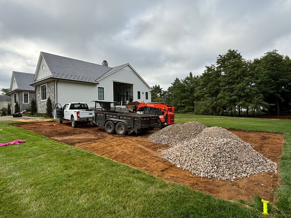 A truck and trailer are parked in front of a house.