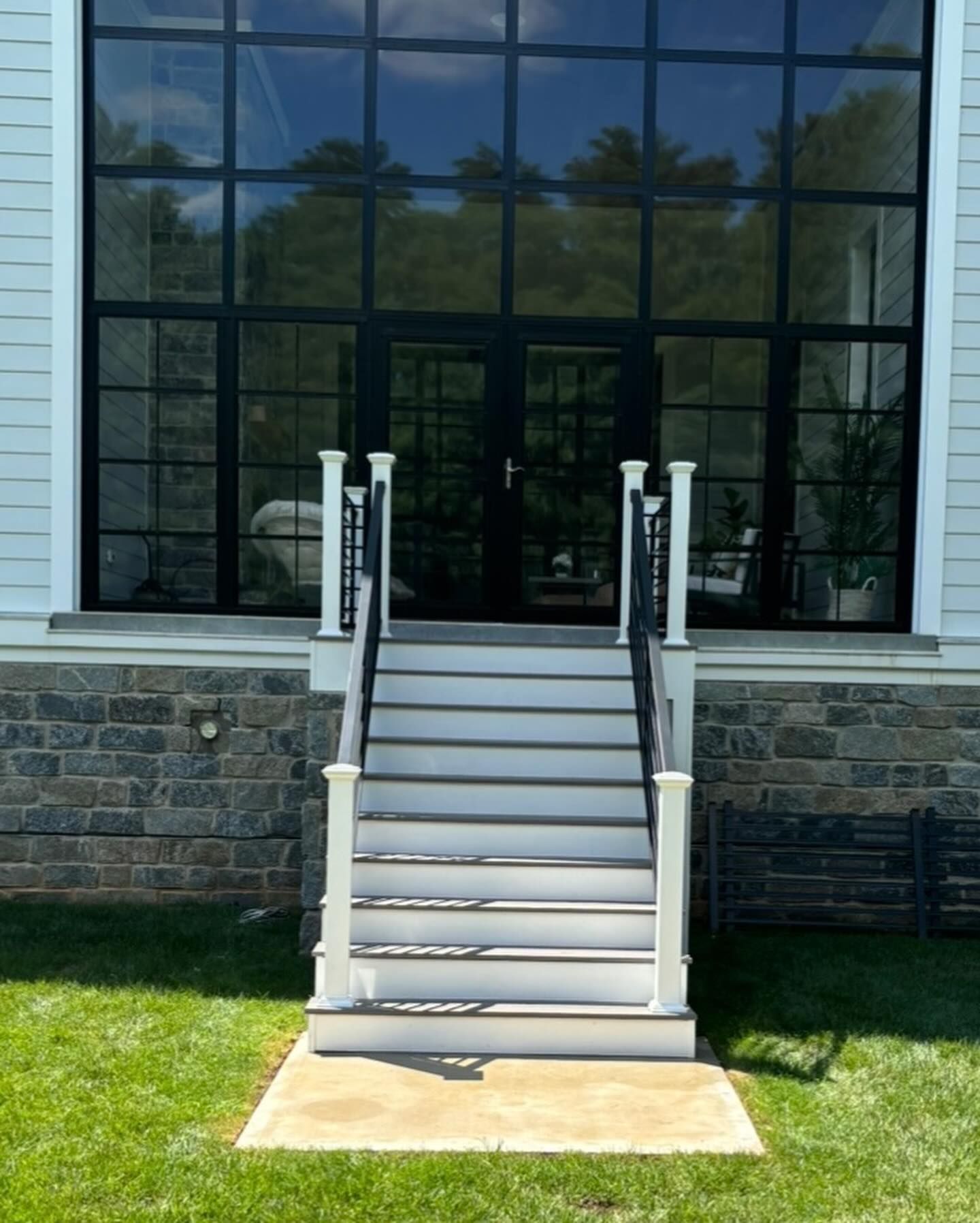 A white porch with stairs leading up to the front door of a house.