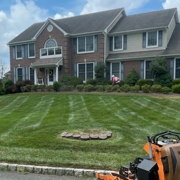 A large brick house with a lush green lawn in front of it
