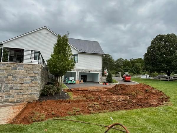 A large white house with a large pile of dirt in front of it.