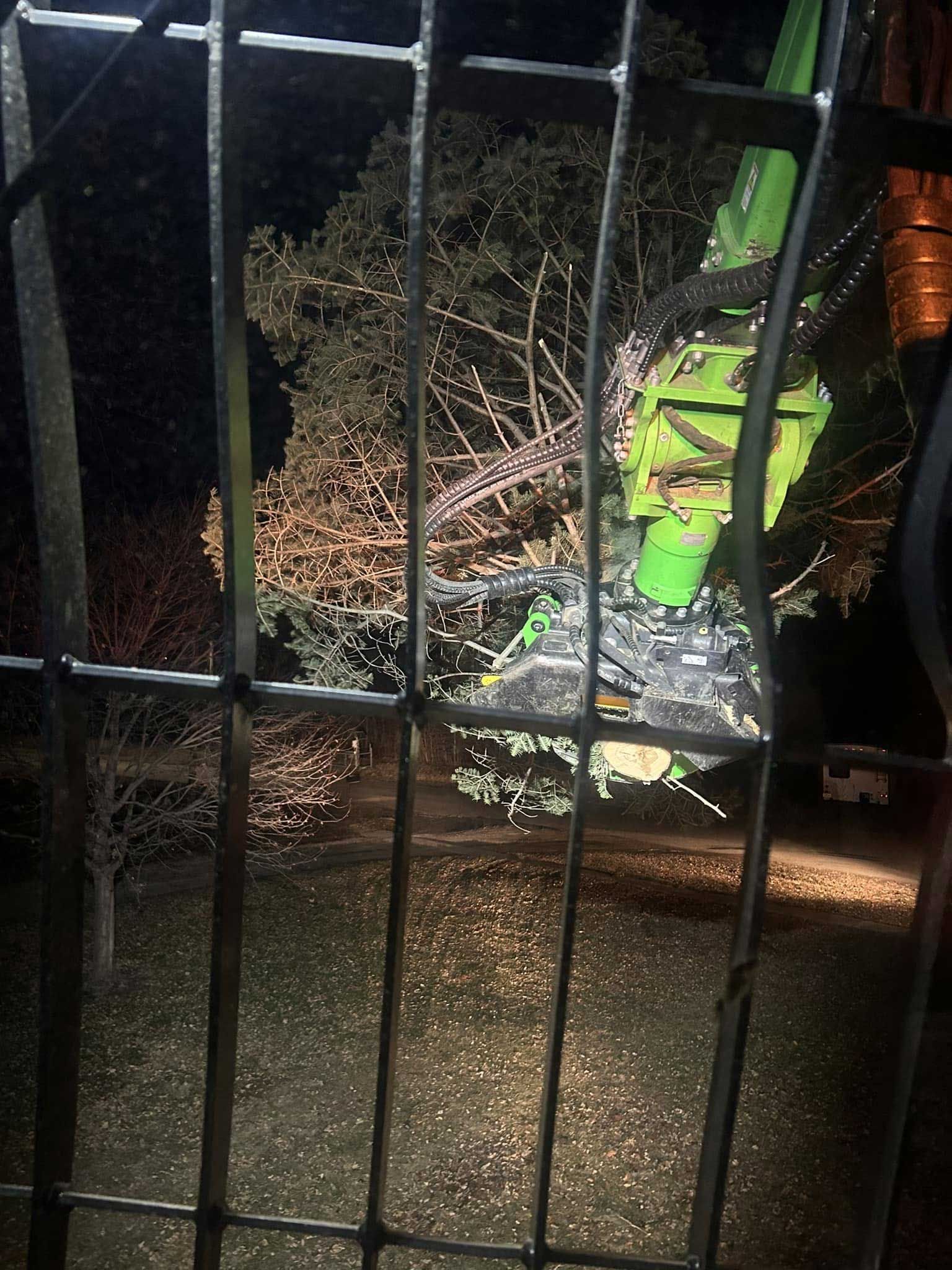 Green machine behind a metal gate at night.