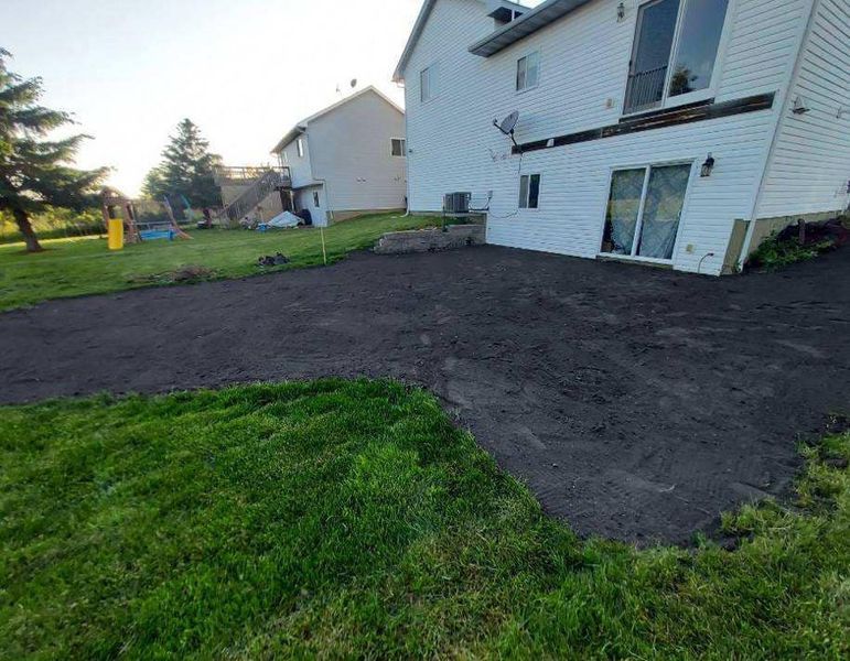 A white house with a black driveway in front of it.