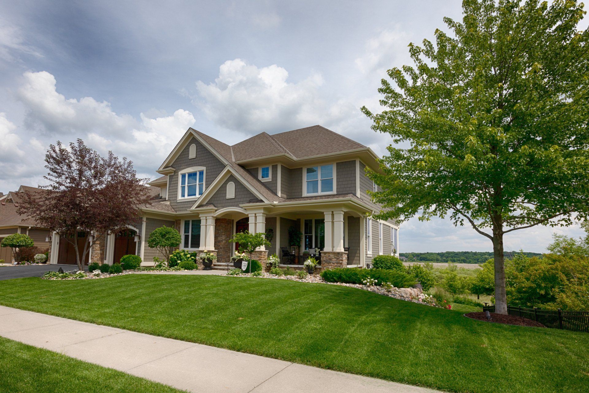 A large house with a lush green lawn and trees in front of it