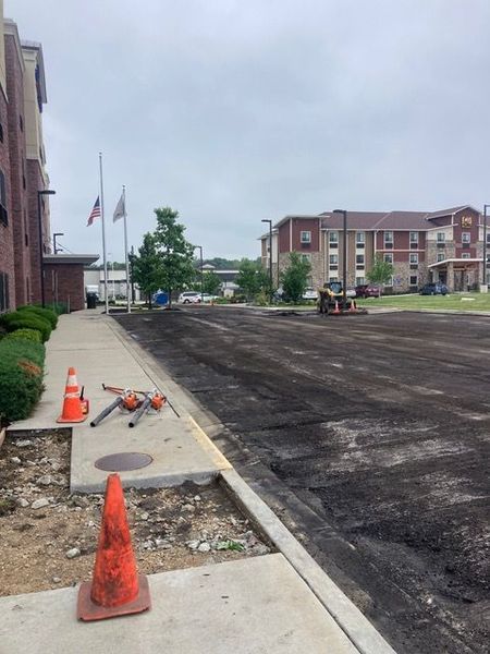 Asphalt resurfacing work in progress; parking area outside a hotel.