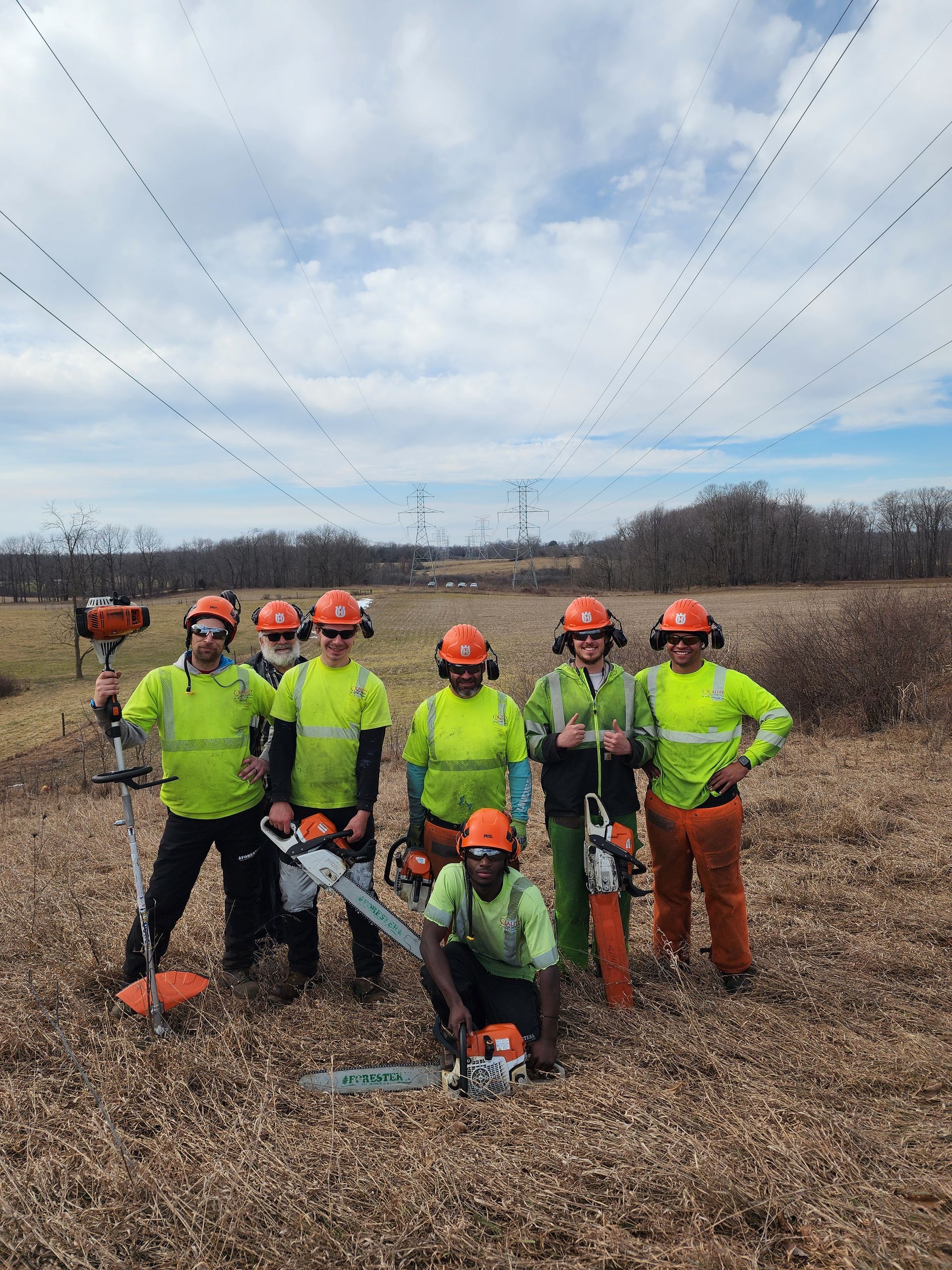 A group of workers are posing for a picture in a field.