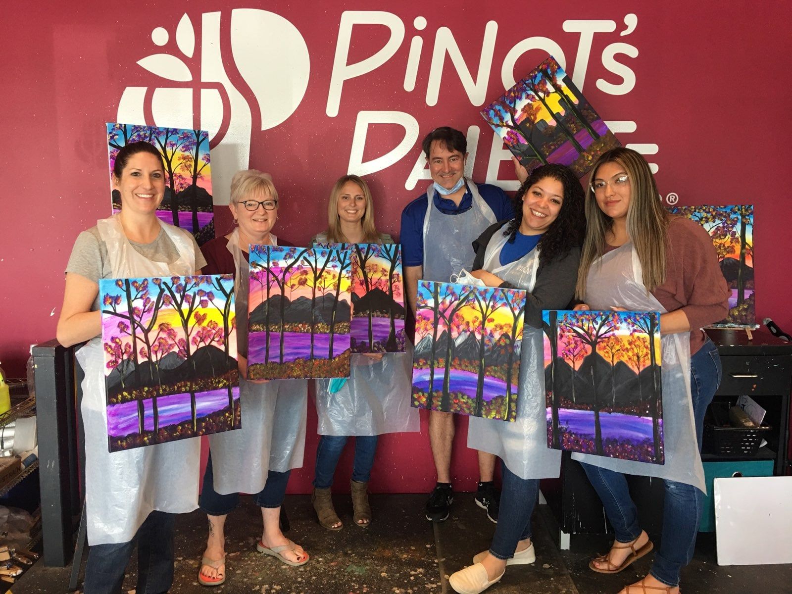 Dental staff holding their paintings