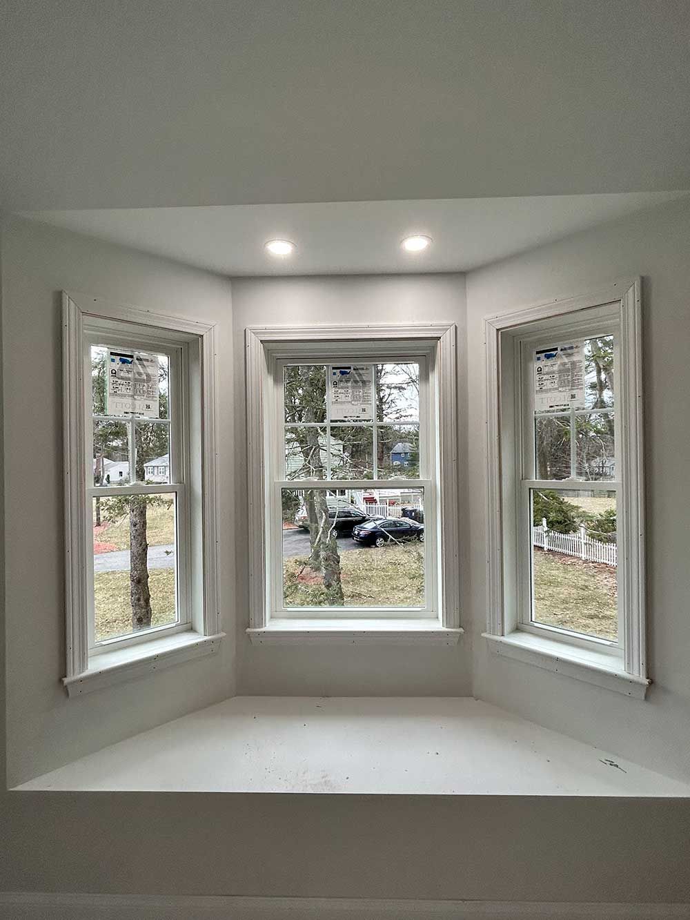 A room with two windows and a window seat.