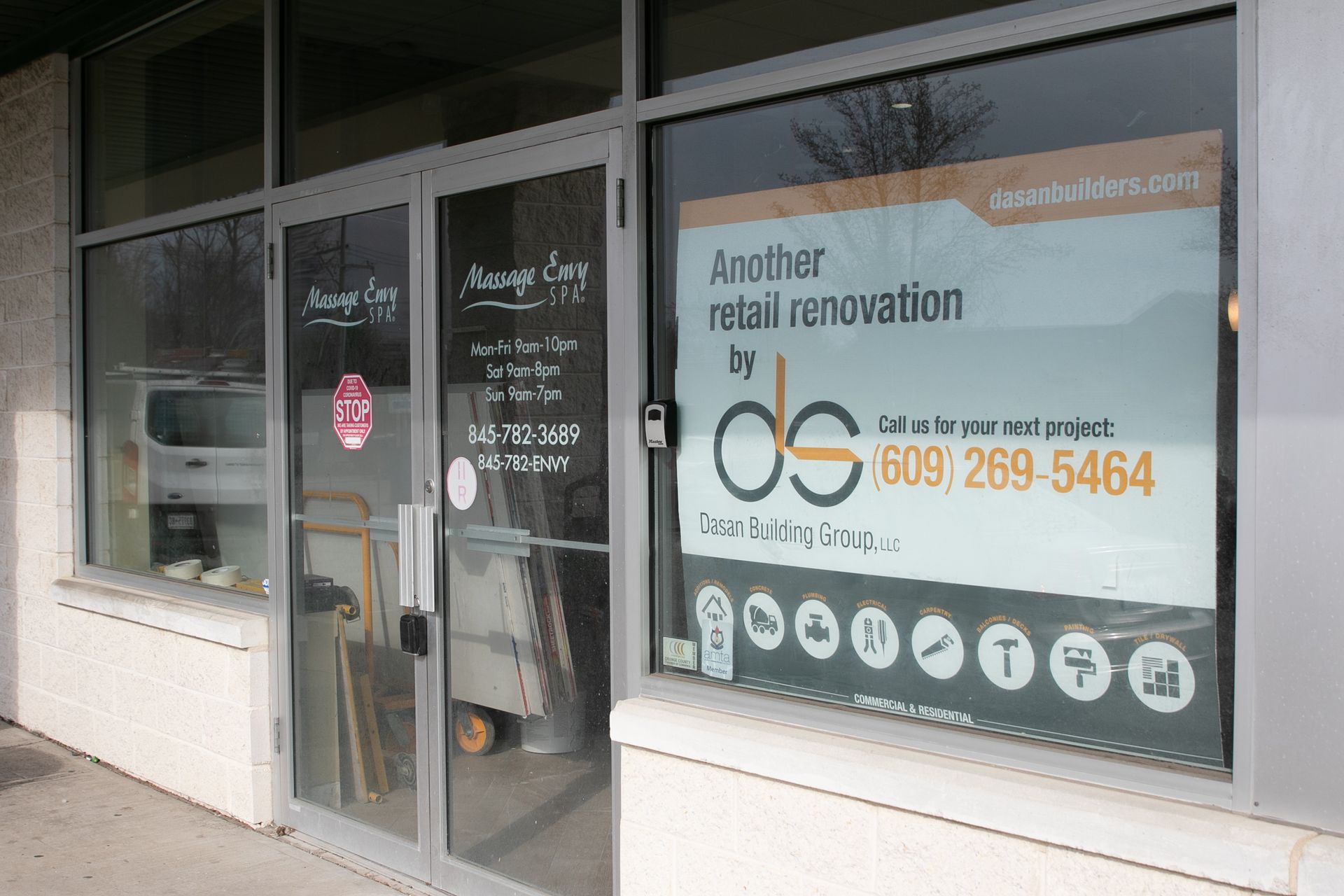 Exterior of a business, featuring a window with a renovation advertisement and the door of a jewelry store.