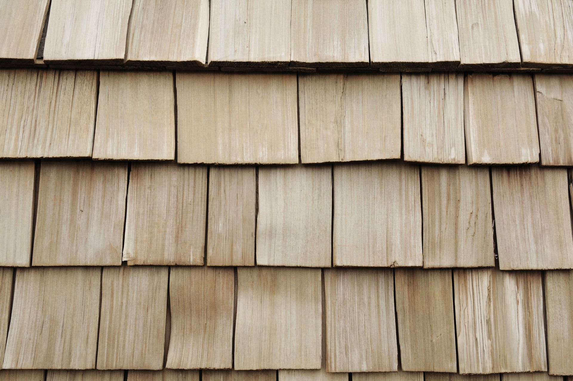 Close-up of weathered wooden shingles arranged in overlapping rows.