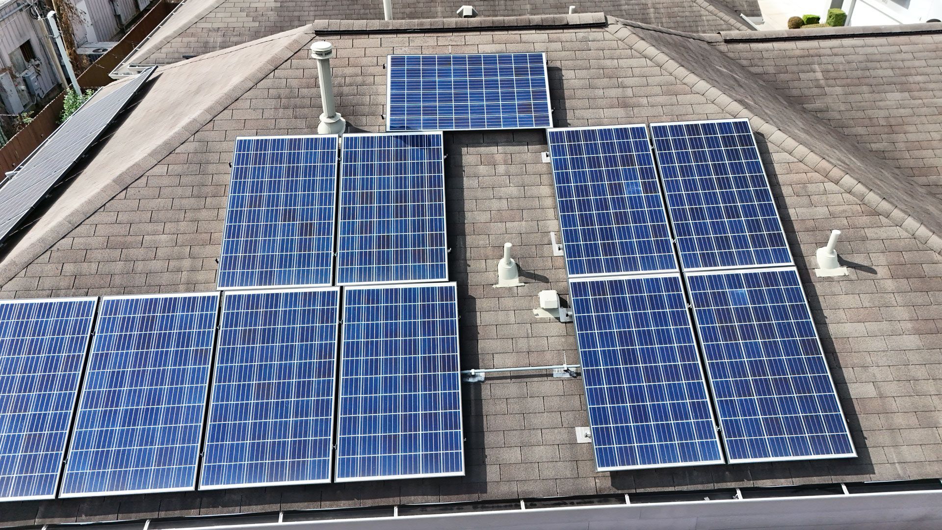 Solar panels installed on a dark rooftop.