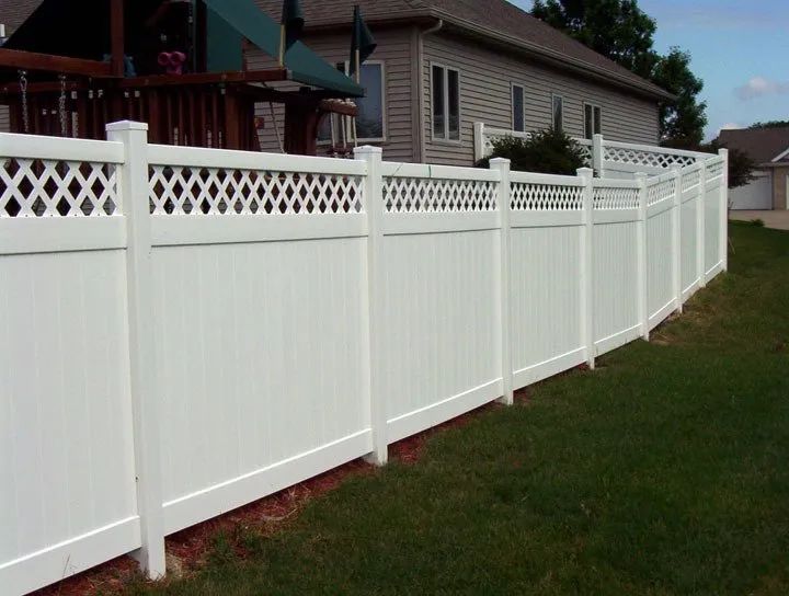 White vinyl fence with lattice top in a suburban yard.