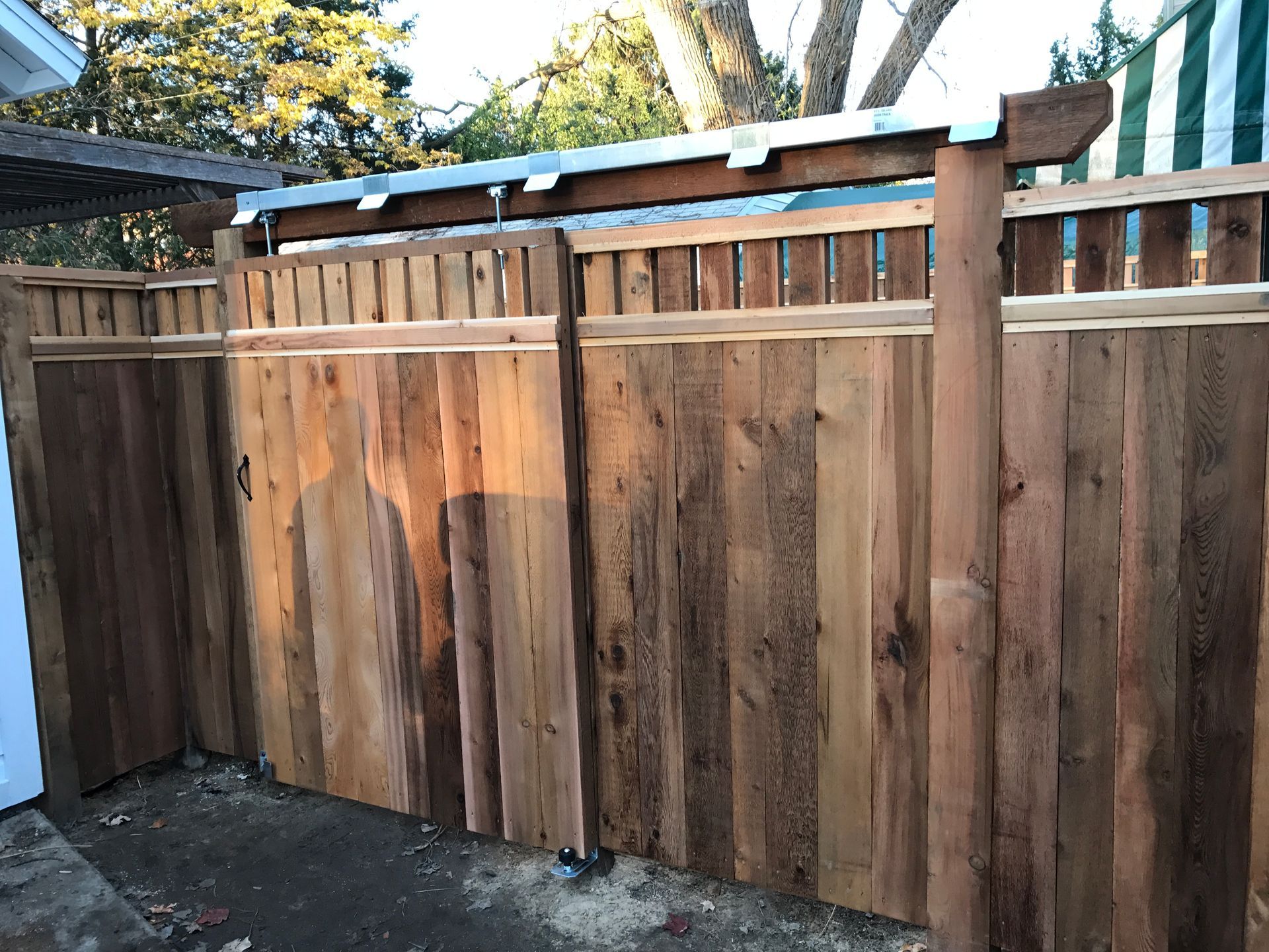 Wooden fence with gate, brown, outdoor setting. Sunlight illuminates boards.