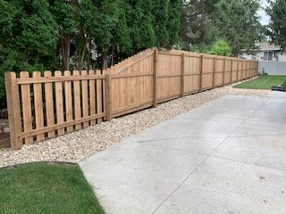 Wooden fence along a gravel path and grassy area.