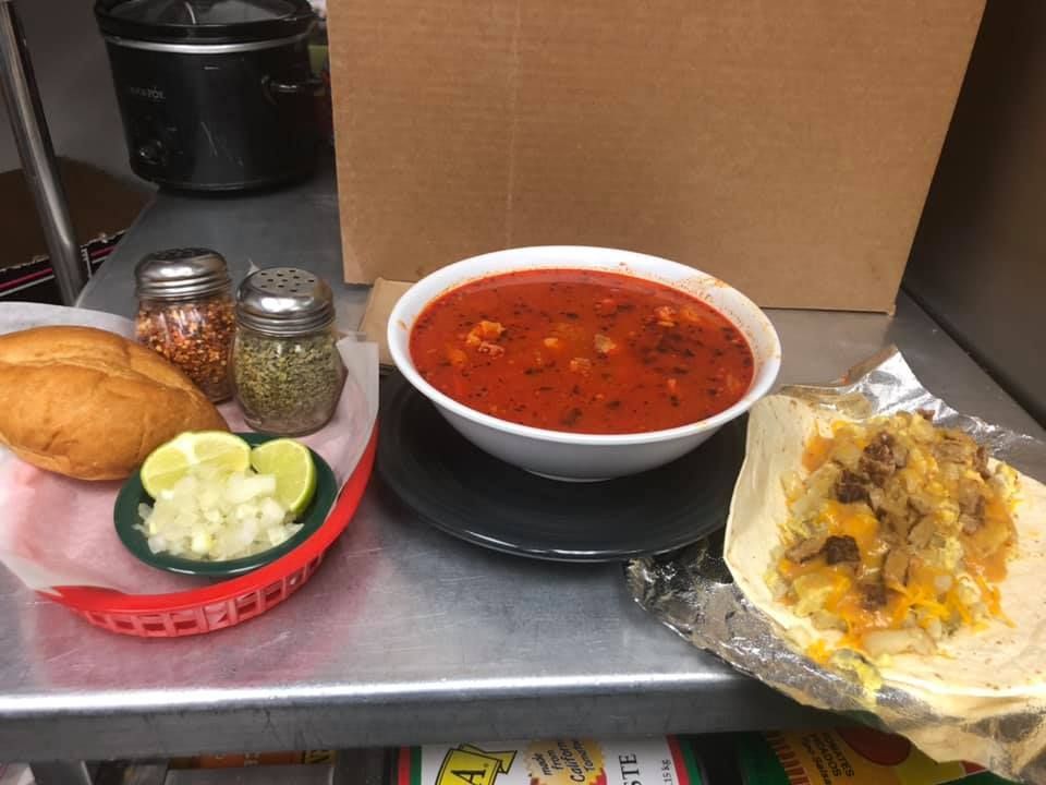 A bowl of soup and a sandwich are on a table.