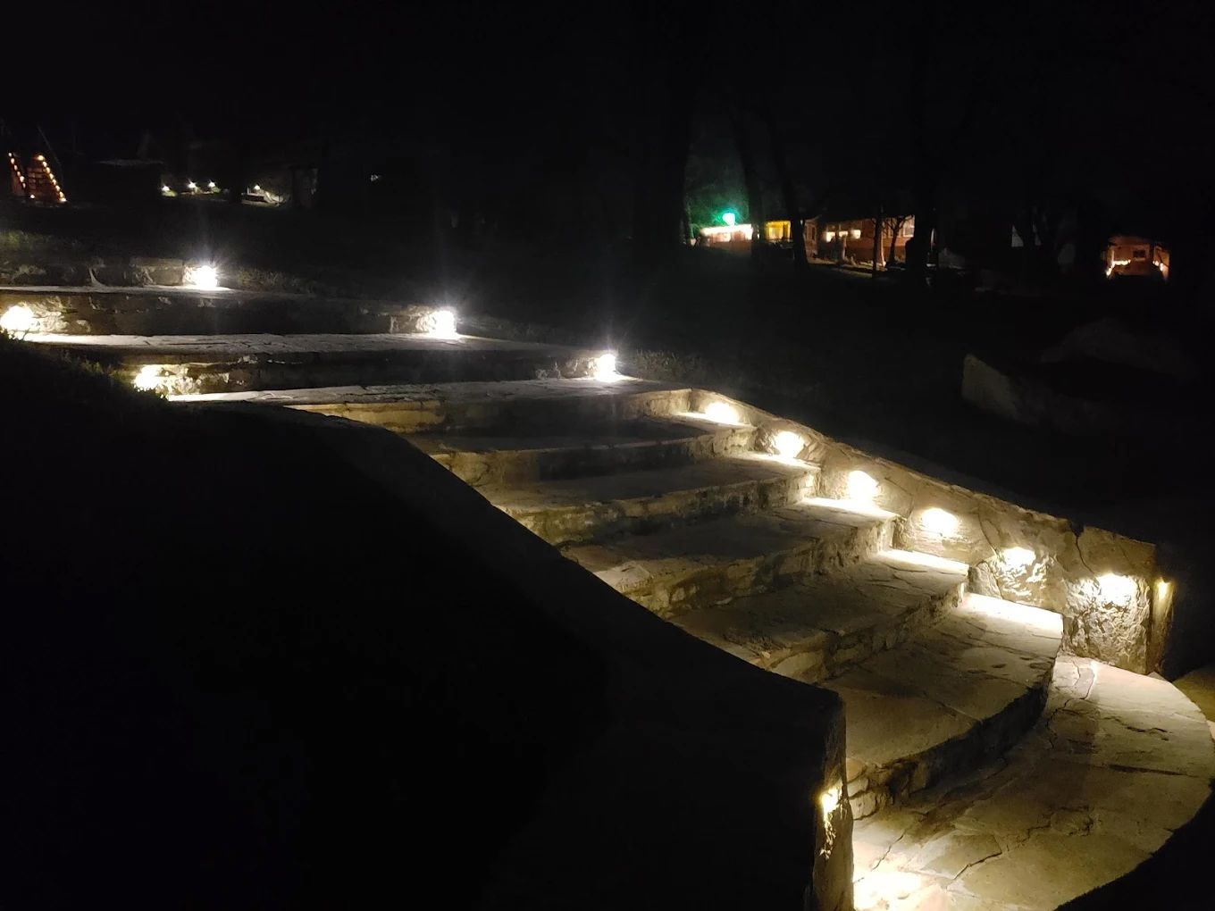 Stone steps illuminated by lights at night.
