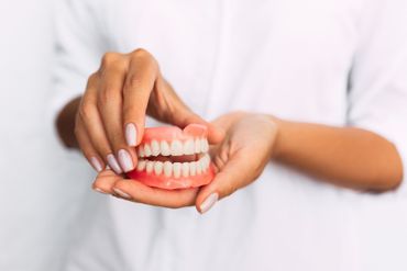 Dentist Holding a Denture