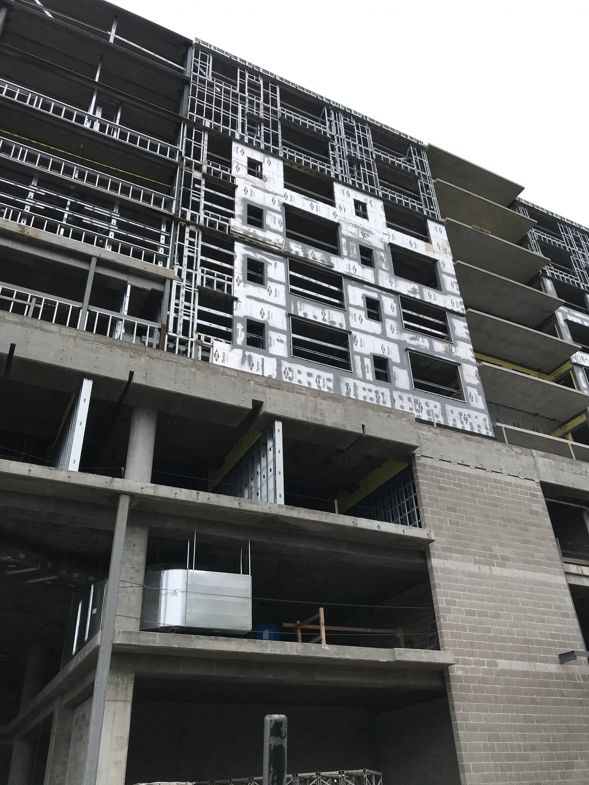 Building under construction with steel framework and concrete floors.