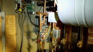 Heating system components with copper pipes and electrical wiring.