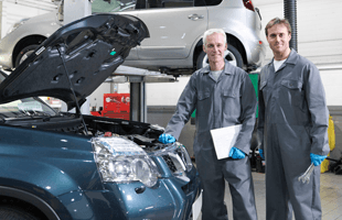 Professional mechanics beside an opened hood car