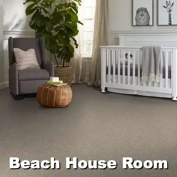 A light carpeted nursery with a crib, rocking chair, and a potted plant. The words